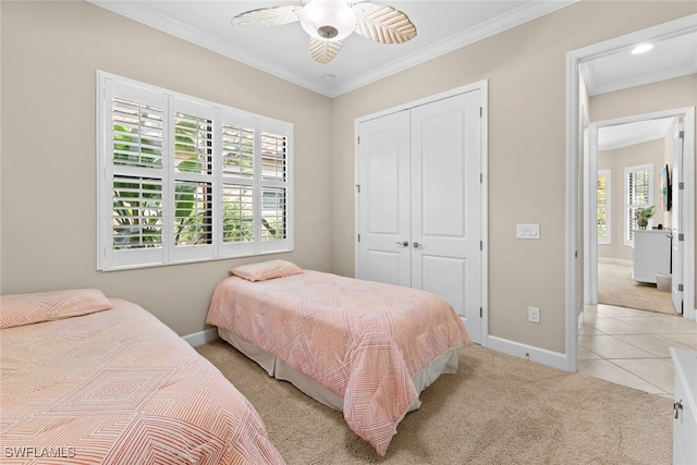 bedroom with a closet, ornamental molding, light colored carpet, and ceiling fan