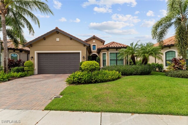 mediterranean / spanish house featuring a front lawn and a garage