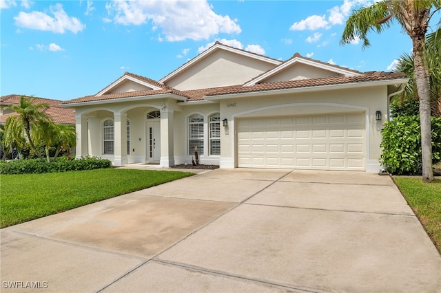 mediterranean / spanish-style house featuring a front yard and a garage