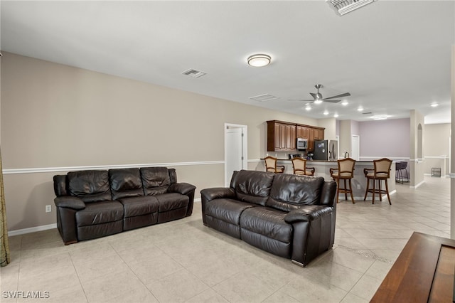 living room featuring light tile patterned floors and ceiling fan