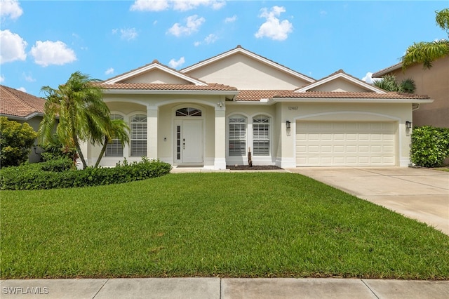 mediterranean / spanish house with a front lawn and a garage