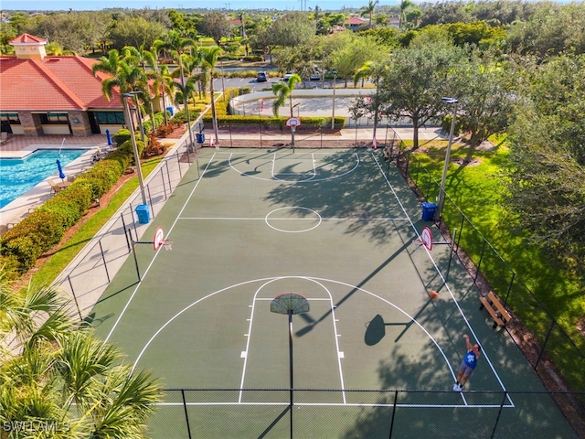 view of basketball court with a fenced in pool