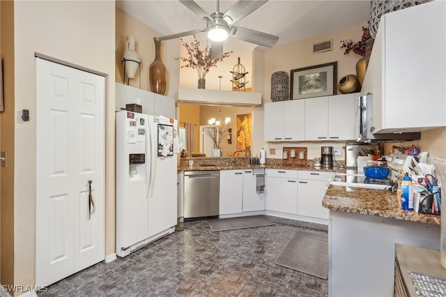 kitchen featuring white cabinets, ceiling fan, stainless steel dishwasher, dark stone countertops, and white refrigerator with ice dispenser