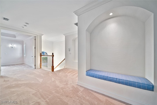 corridor with crown molding and light carpet