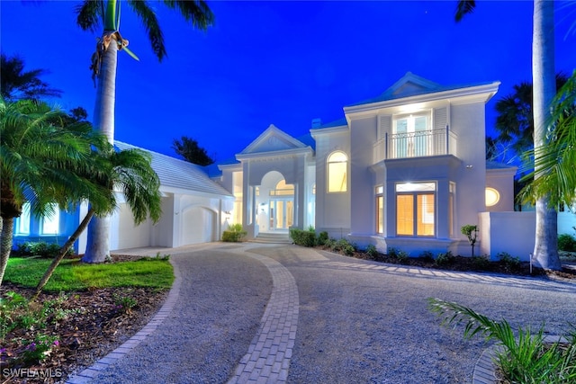 view of front of home with a garage and a balcony