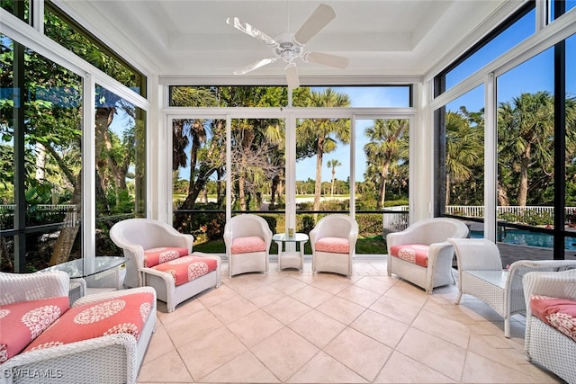 sunroom with ceiling fan and a raised ceiling