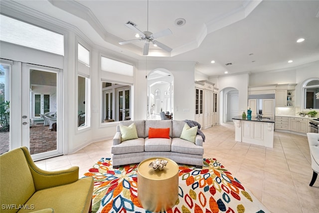 living room featuring a wealth of natural light, crown molding, and ceiling fan