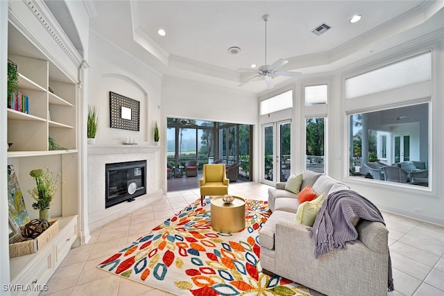 tiled living room featuring a towering ceiling, ceiling fan, ornamental molding, and plenty of natural light