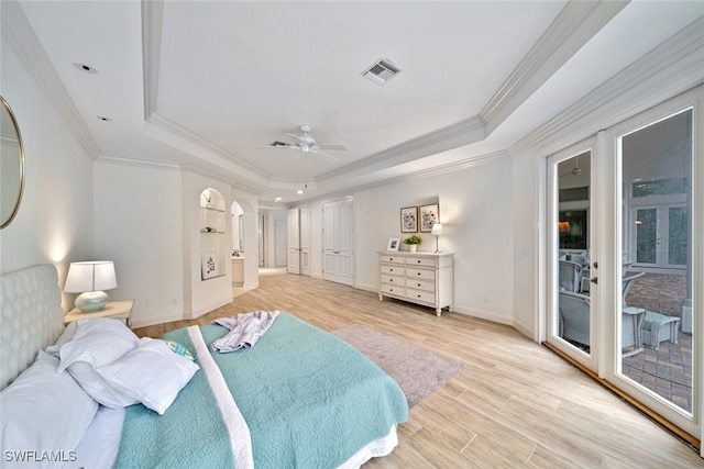 bedroom with ceiling fan, access to exterior, a tray ceiling, ornamental molding, and light hardwood / wood-style floors