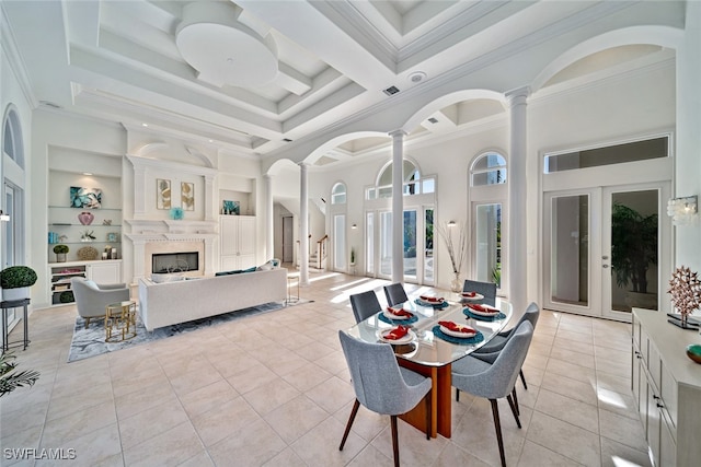 dining area featuring ornate columns, french doors, crown molding, and built in shelves