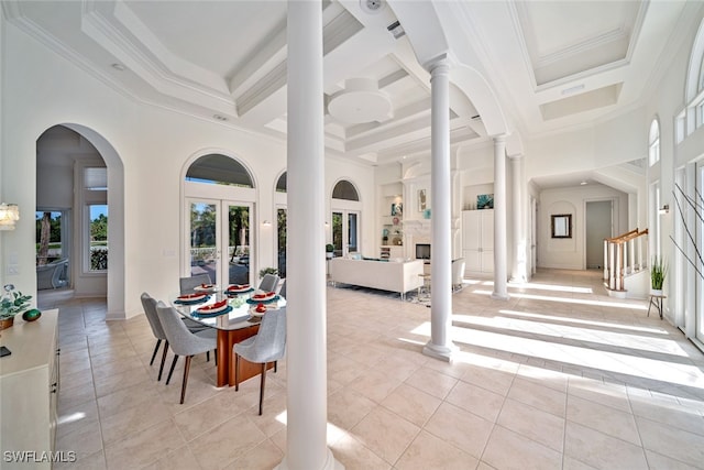 tiled dining area with ornamental molding, ornate columns, a high ceiling, french doors, and coffered ceiling