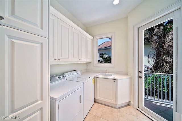 laundry area featuring sink, a wealth of natural light, cabinets, and separate washer and dryer