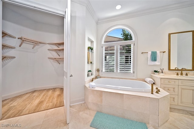 bathroom featuring vanity, ornamental molding, hardwood / wood-style floors, and tiled bath