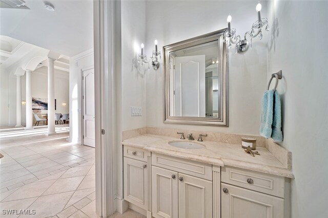 bathroom with vanity, decorative columns, ornamental molding, and tile patterned flooring