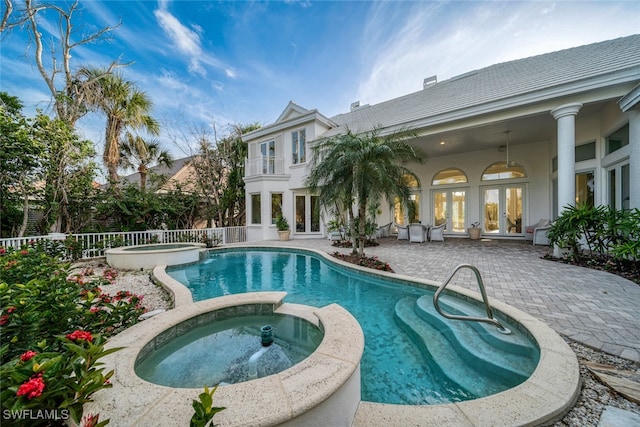 view of swimming pool with a patio area, french doors, and an in ground hot tub