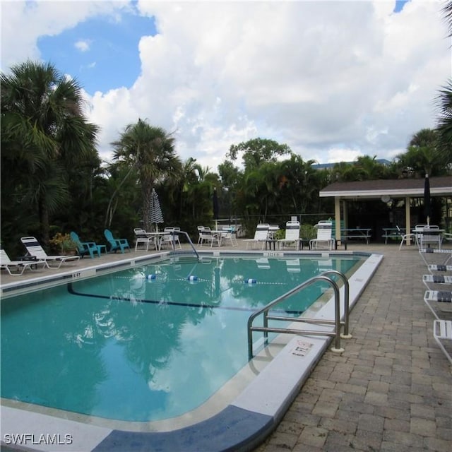 community pool with a patio area and fence