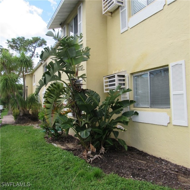 view of home's exterior with a lawn and stucco siding