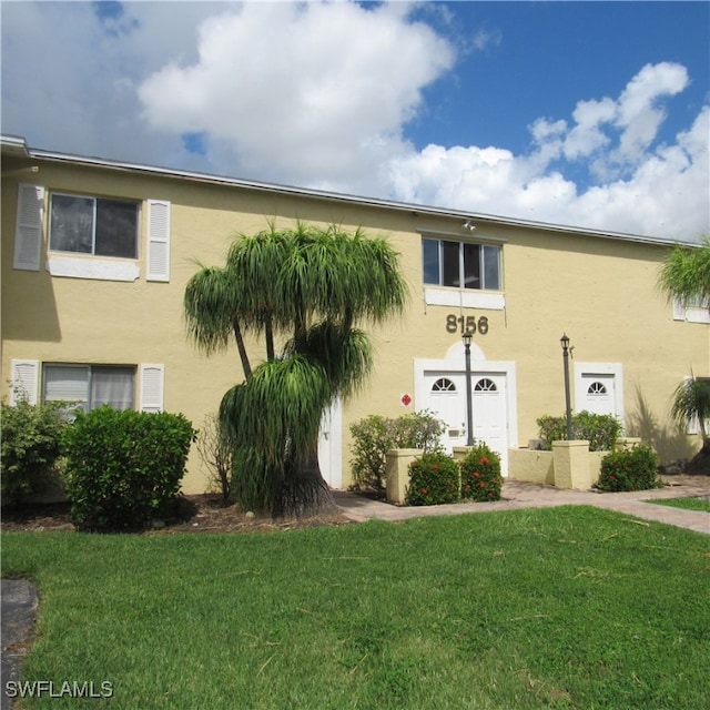 view of front facade featuring a front yard and stucco siding