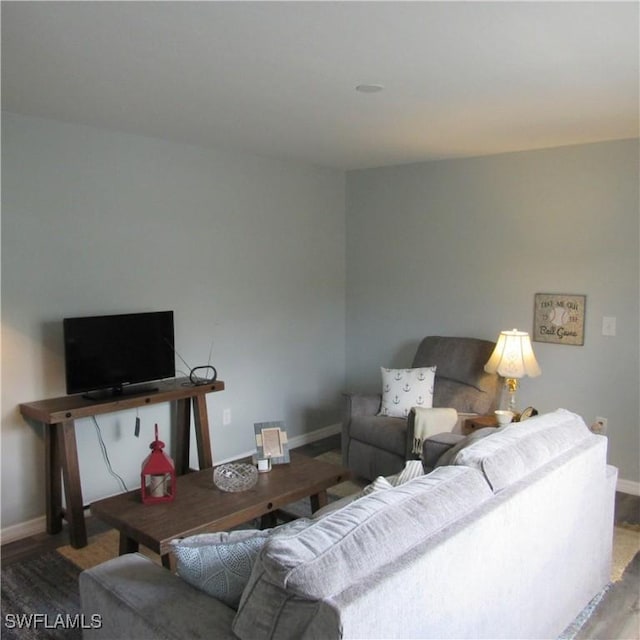 living area featuring baseboards and wood finished floors