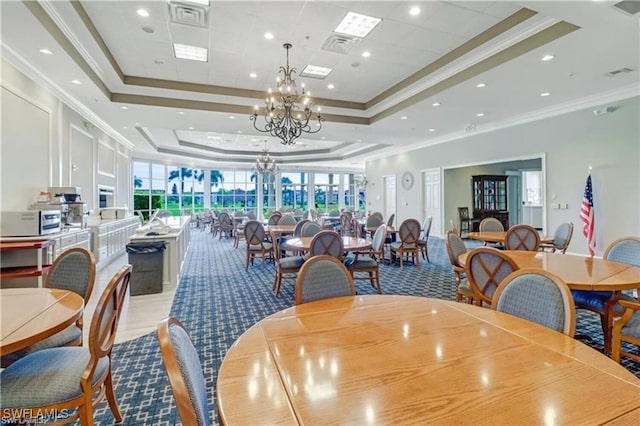 dining space featuring a notable chandelier, crown molding, and a raised ceiling