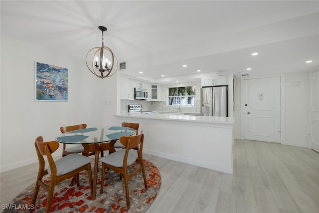 dining area featuring a notable chandelier and light hardwood / wood-style flooring