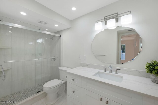 bathroom featuring vanity, a shower with shower door, and toilet