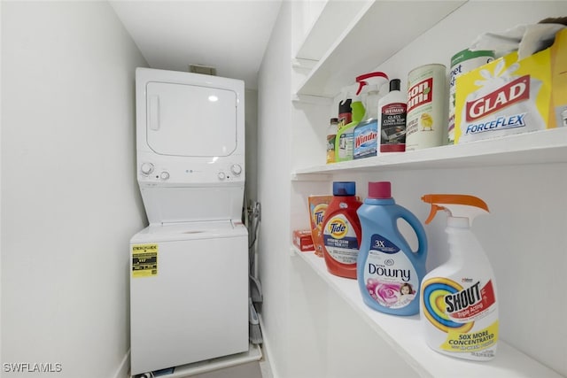 washroom featuring stacked washer and dryer and laundry area