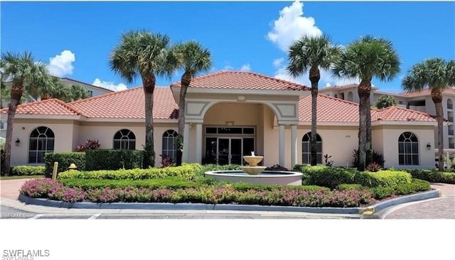 exterior space with a tiled roof and stucco siding