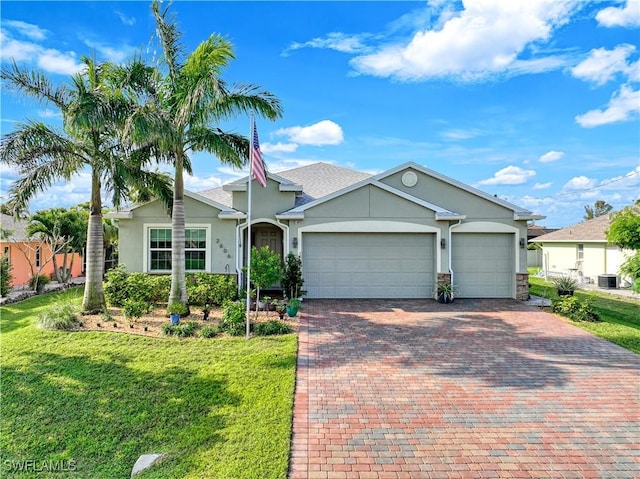 single story home featuring a garage, central air condition unit, and a front yard