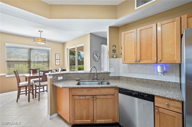 kitchen with kitchen peninsula, appliances with stainless steel finishes, backsplash, sink, and light tile patterned floors