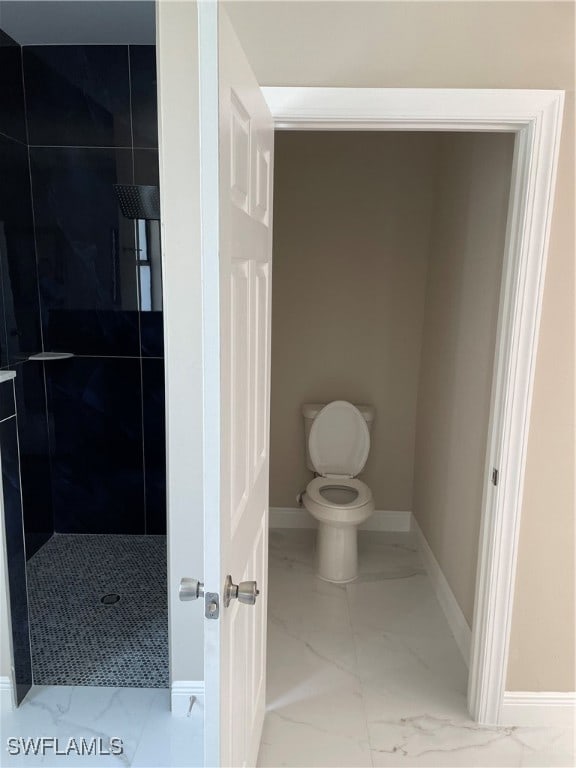 bathroom with tiled shower and toilet