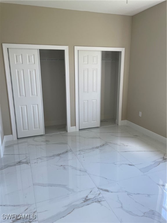 unfurnished bedroom with multiple closets