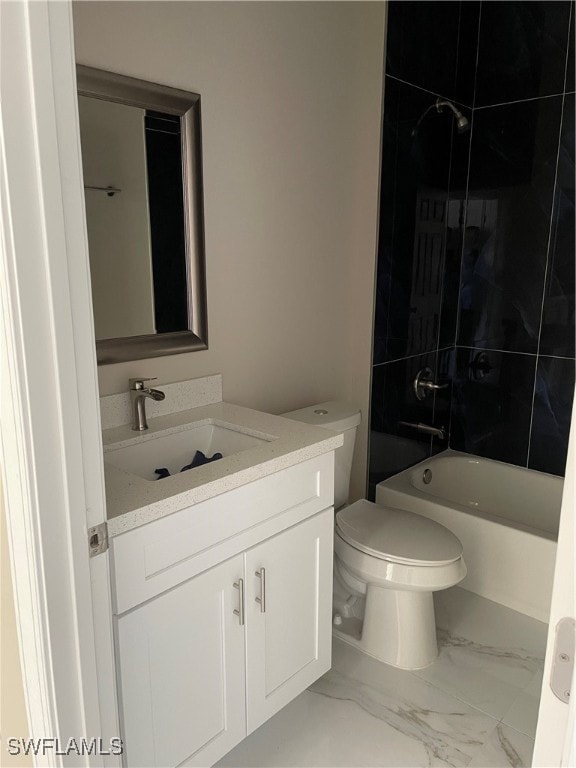 full bathroom featuring tiled shower / bath, vanity, and toilet