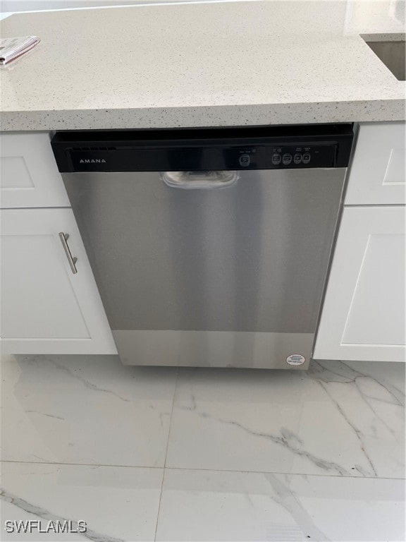 details featuring white cabinetry, light stone counters, and stainless steel dishwasher