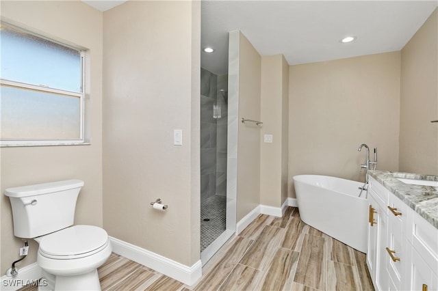 full bathroom with toilet, hardwood / wood-style floors, vanity, and separate shower and tub