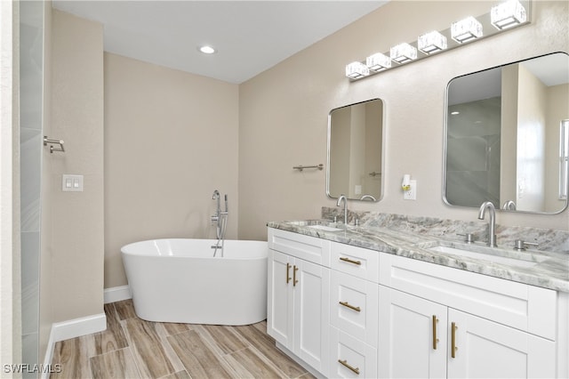 bathroom featuring vanity, a tub, and wood-type flooring