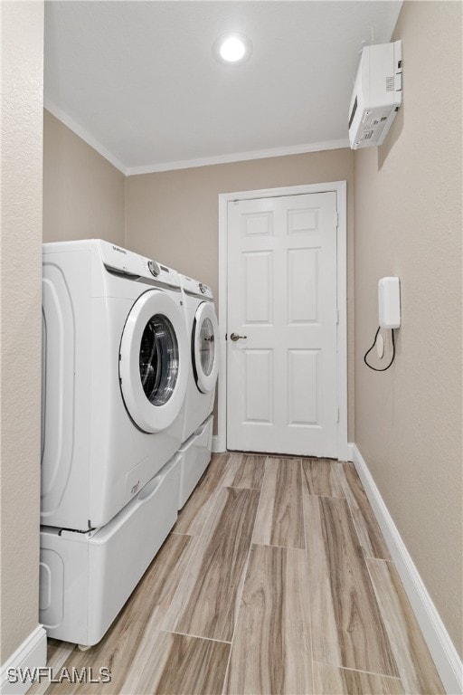 laundry area with light wood-type flooring, crown molding, separate washer and dryer, and a wall unit AC