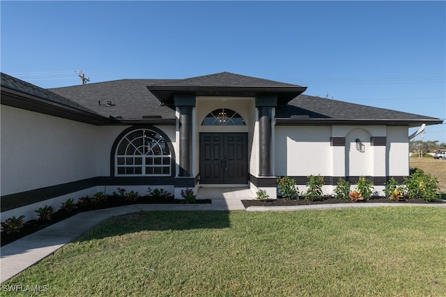 view of exterior entry with a yard