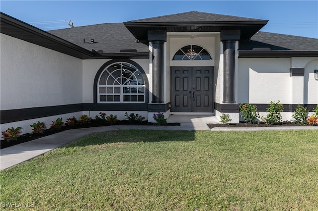 view of exterior entry featuring a lawn