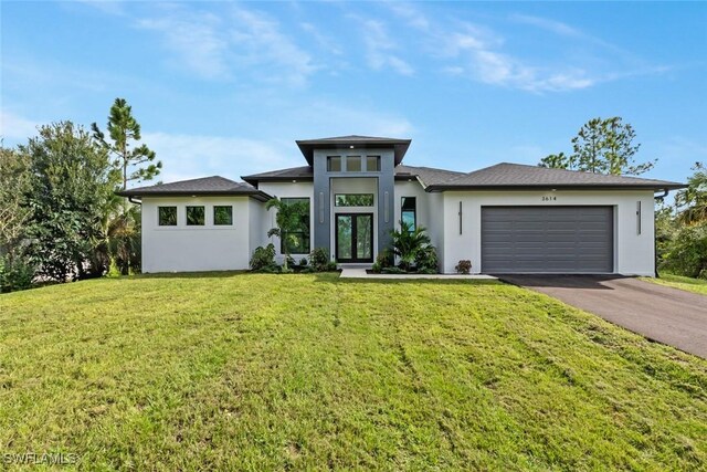 prairie-style home featuring a garage and a front lawn