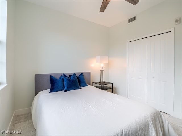 bedroom featuring light tile patterned flooring, ceiling fan, and a closet