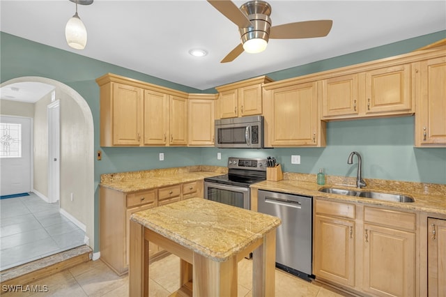 kitchen featuring ceiling fan, pendant lighting, light tile patterned floors, sink, and stainless steel appliances