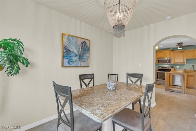 dining area with light tile patterned floors, sink, and a chandelier