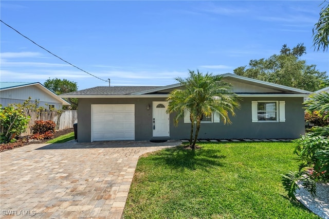 ranch-style house featuring a garage and a front lawn