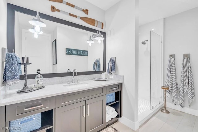 bathroom featuring tiled shower, vanity, and tile patterned flooring