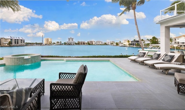 view of pool featuring a water view, a patio area, and an in ground hot tub