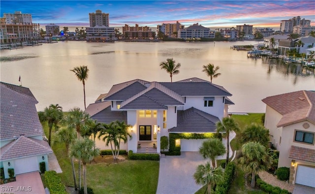 aerial view at dusk featuring a water view