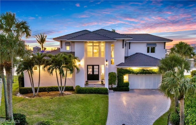 view of front of home with a garage and a lawn