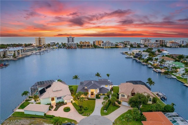 aerial view at dusk featuring a water view