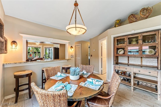 dining area featuring light wood-type flooring and baseboards